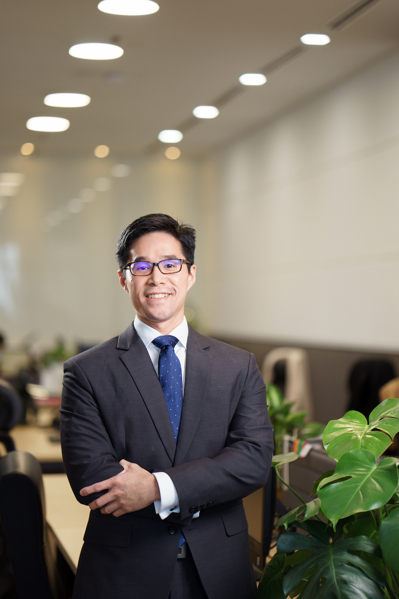 Portrait of Terrence Edward Chong, partner at Darryl, Edward & Co., standing confidently in a modern office