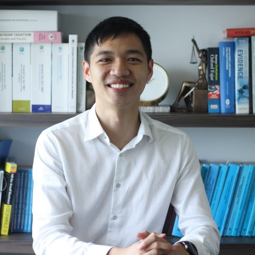 A photo of Ooi Zi Jie - An Associate in professional attire, sitting at her desk at Darryl Edward & Co.
