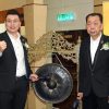 Portrait of Winstar beside a gong, preparing to strike it